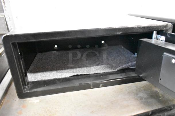 Black metal single compartment safe, open door, no combinations provided, interior lined with fabric, shows two holes on back wall.