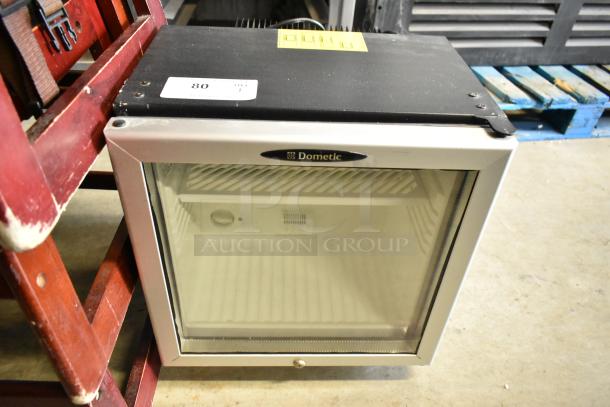 Dometic RH023LDAG Mini Cooler Merchandiser, metal frame, glass door, 115 volts, 1 phase, visible model and brand labels.