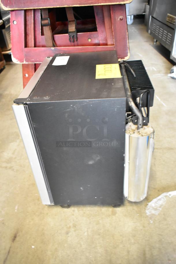 Dometic RH023LDAG metal mini cooler merchandiser, 115 volts, 1 phase, black finish, side view, showing label and components.