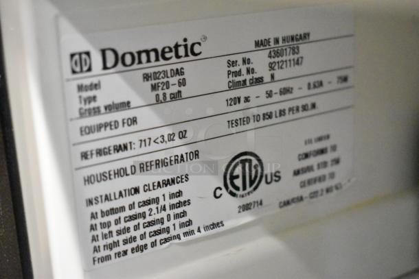 Dometic RH023LDAG metal mini cooler label detailing model, voltage, refrigerant type, and installation clearances.