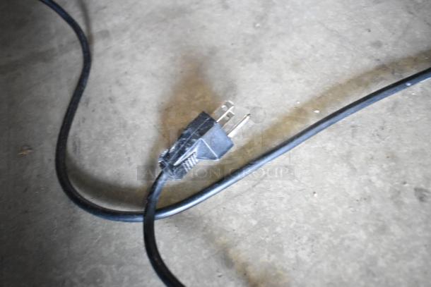 Power cord of a Dometic RH023LDAG Mini Cooler Merchandiser on a concrete floor. 115 Volts, 1 Phase.