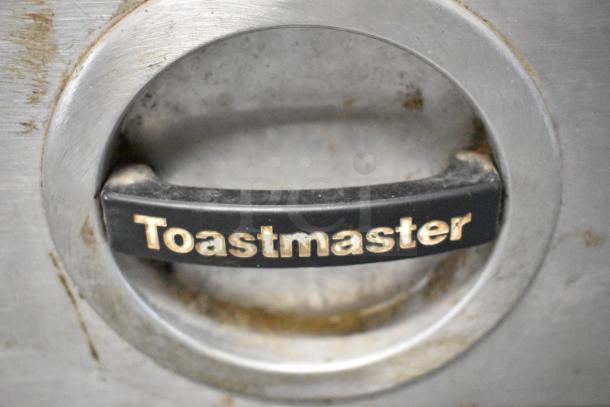 Toastmaster 3ABOA warming drawer handle with brand logo, stainless steel, some wear visible. Suitable for commercial use.