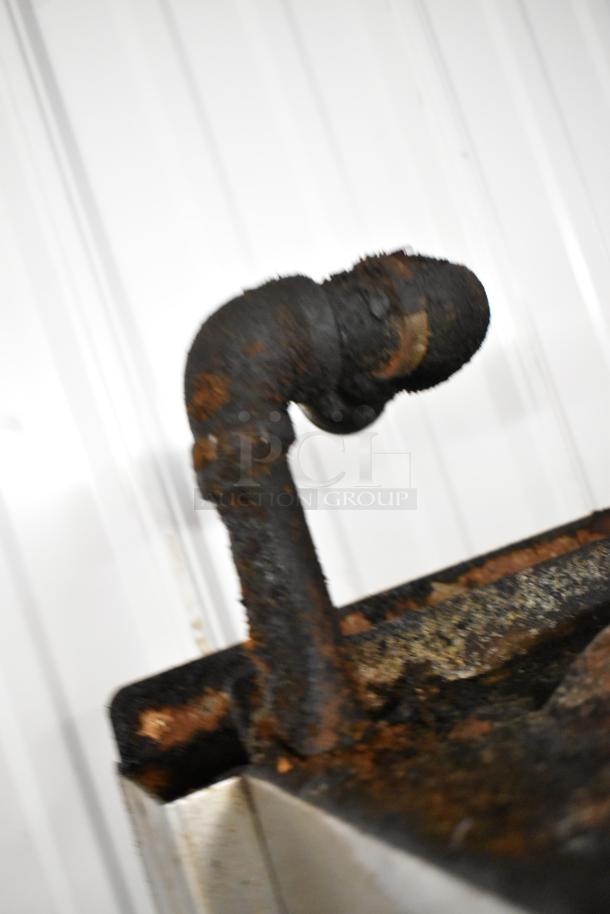 Rusted section of a Garland stainless steel commercial range component. Condition suggests wear and aging.