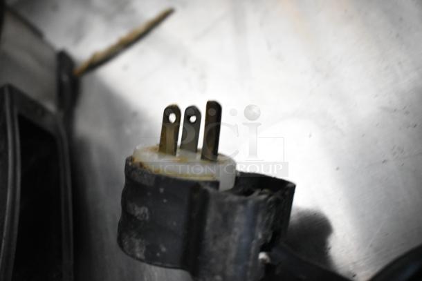 Close-up of a power plug for the Somerset CDR-100P dough sheeter, showing a three-prong design in used condition.
