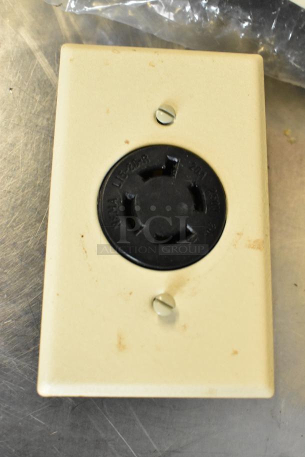 Beige electrical outlet cover with a black NEMA L6-20R outlet, showing wear. Features 14 outlets, enhancing appeal.