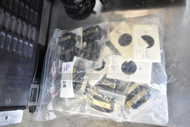 Bag of 14 electrical outlets with plates, part of an auction lot. Includes labels with codes "1B" and "2B" visible.