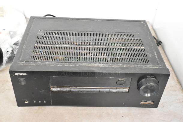 Onkyo AV Receiver model TX-SR373, black with visible buttons and knobs, fair condition, on dining table.