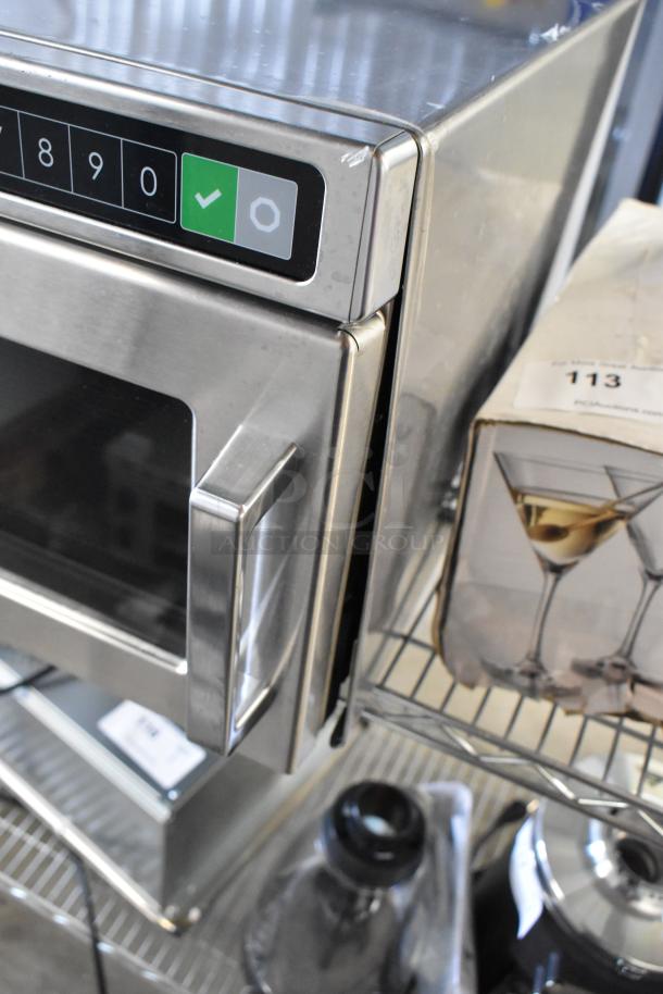 BRAND NEW Amana HDC12A2 commercial microwave, stainless steel, push button controls, 120V, minor scratches visible.