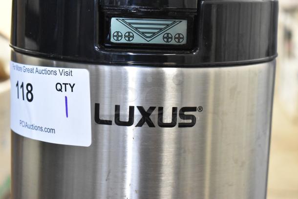 Brand new Fetco Luxus L4D-10 1-gallon stainless steel coffee server with stand, visible auction tag, slight scratches.