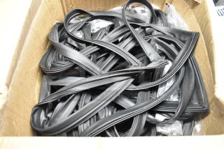 Box of black rubber door seals, new condition, stored in a cardboard box, ideal for weatherproofing.