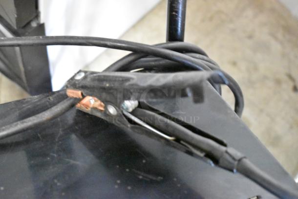 Schumacher SE 8050 Battery Charger, showing clamps and cables. Used condition. Suitable for charging automotive batteries.