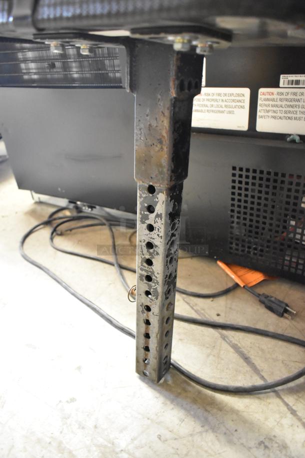 Rusted metal frame with adjustable holes for exercise bicycle seat attachment.