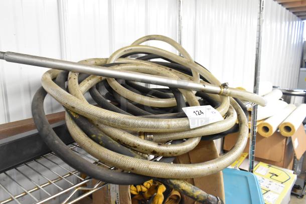 A set of two industrial hoses coiled on a metal shelf, marked with auction lot number 124.