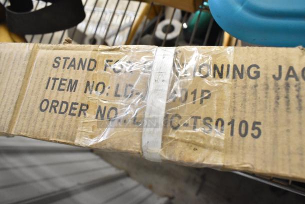 Box labeled "Stand for Jack," item and order numbers, part of a mixed lot including stand, metal pieces, and strap.