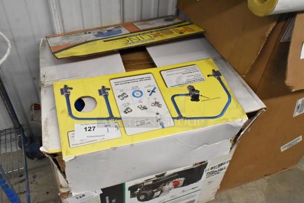 Cardboard box containing tubing and connectors, dented and partially opened. Labels show item number 127 for auction.