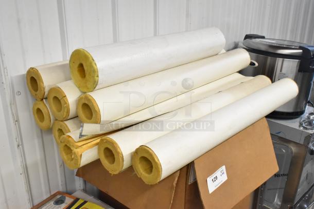 Lot of various items including rolls of insulation and a rice cooker. Insulation appears unused, placed on cardboard boxes.