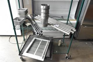 Auction lot includes stainless steel drop-in bins, metal rods, and assorted materials on a two-tier green cart.