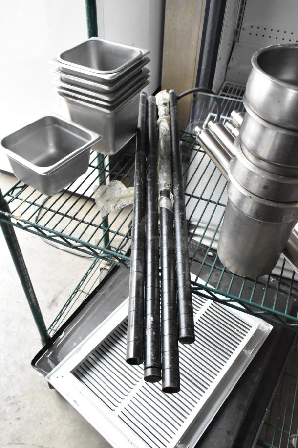 Lot of stainless steel drop-in bins, metal rods, and industrial items on shelves. Used condition, ideal for storage solutions.
