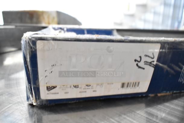 Brand new T&S faucet box, visible scratch and dent, with partial label showing item codes and barcode.
