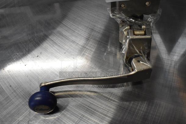 Brand new Edlund 905 metal commercial can opener with mount, scratch and dent condition, wrapped in protective plastic.