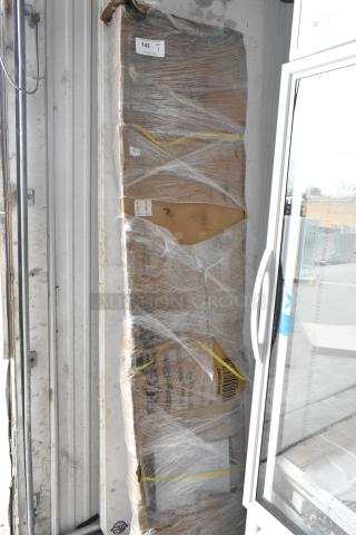 Brand new scratch and dent 600TB1884G Regency 18"x84" stainless steel commercial work table, packed and wrapped, with visible packaging wear.