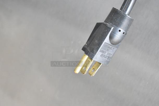 Black electrical plug with text "Connect to grounded outlet" on a gray background.