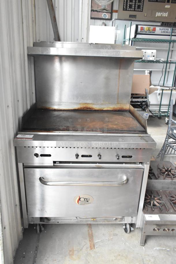 Stainless steel CPG commercial gas griddle with oven, over shelf, backsplash, and commercial casters. Used condition.