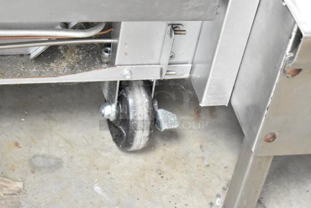 Cooking Performance Group commercial griddle caster wheel; shows part of the stainless steel frame, indicating mobility.