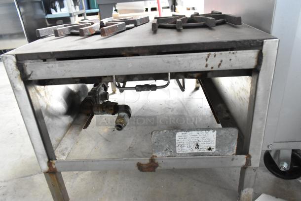 Metal commercial countertop gas-powered 4 burner 2-tier range with visible rust and signs of wear; includes connection fittings.