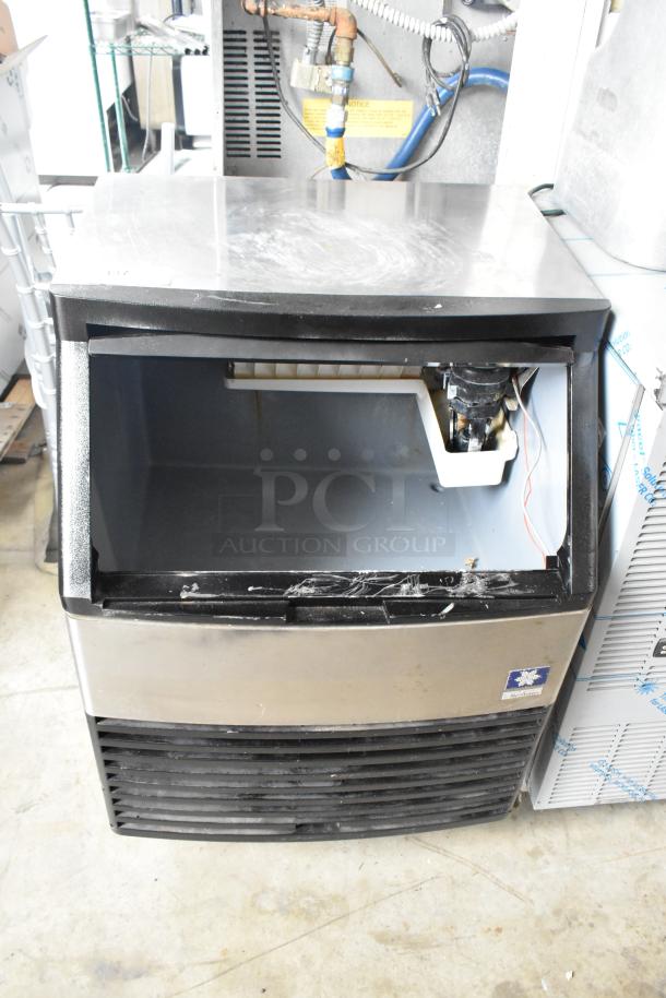 Manitowoc QY0134A stainless steel undercounter ice machine, self-contained, visible wear, functional interior components.