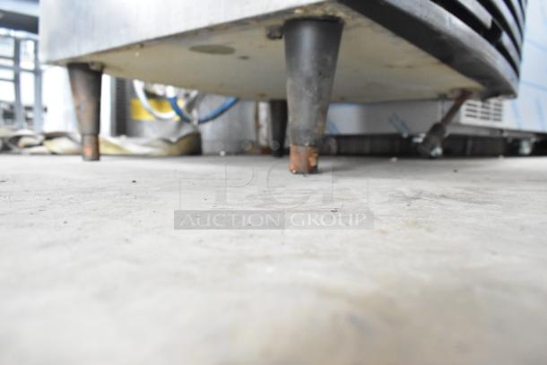 Stainless steel Manitowoc QY0134A ice machine, commercial grade, undercounter, minor wear on legs visible.