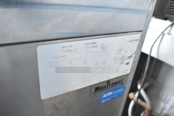 Manitowoc QY0134A ice machine, stainless steel, undercounter model, with visible model and serial number labels.