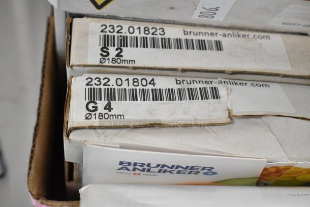Brand new Brunner Anliker food processor blades, 11 pieces. Labels show model G4 and S2, 180mm diameter, Swiss made.