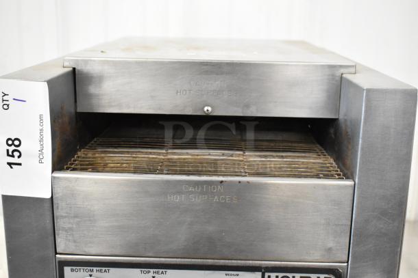 Holman stainless steel conveyor toaster oven, 115 volts, 1 phase, commercial grade, visible “Caution Hot Surfaces” label.