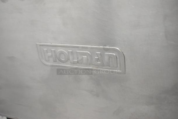 Holman stainless steel commercial countertop conveyor toaster oven, 115 volts, 1 phase, embossed logo visible on surface.