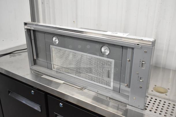 ZPI-E30AG290 metal range hood in gray, featuring dual lights and a mesh filter, in good condition. Auction lot number visible.