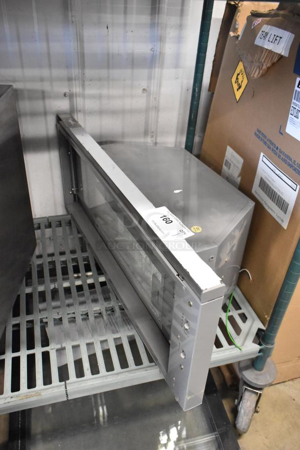 ZPI-E30AG290 metal range hood on a shelf; features buttons and mesh filter. Appears in good condition.
