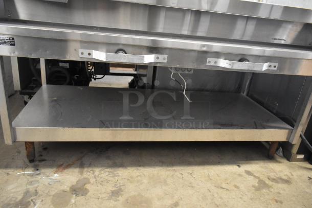 Stainless steel commercial electric steam table, 208 volts, showing two serving slots and control knobs, moderate wear.