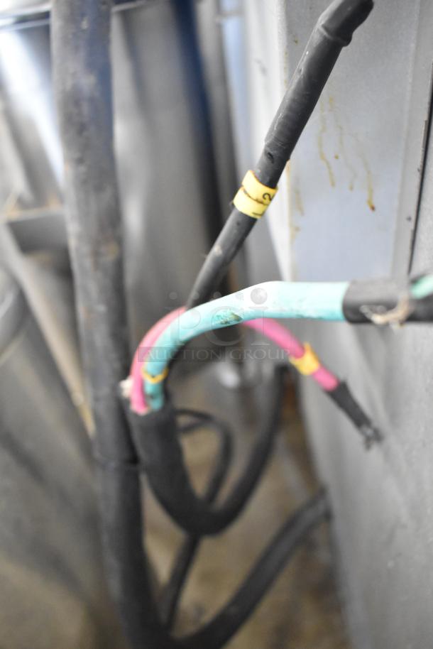 Close-up of wires on a Cookline 4-burner stainless steel commercial range, showcasing electric connections.