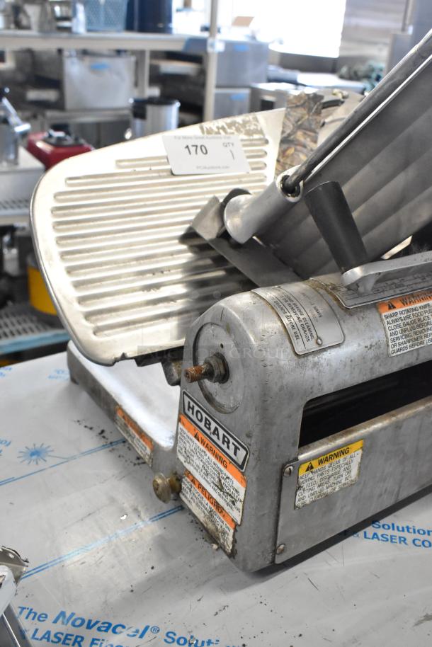 Hobart 1612 stainless steel commercial meat slicer, countertop model, 115V, 1-phase, with visible safety warnings and use labels.