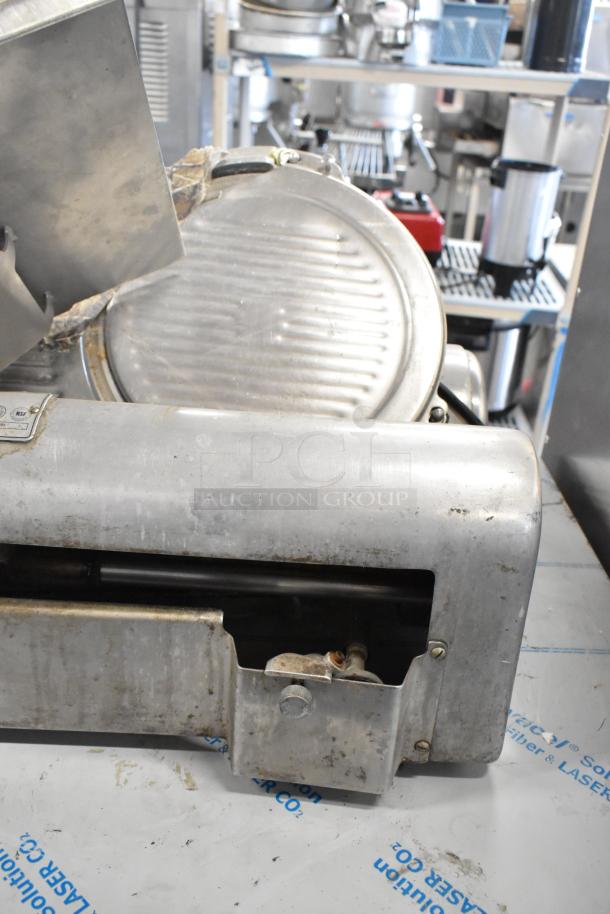Hobart 1612 stainless steel commercial meat slicer, 115 volts, 1 phase, visible wear, NSF label, suitable for countertop use.