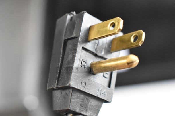 Close-up of a power plug for the General Electric ZDIS15SSHRHA ice machine, showing prongs and detail markings.