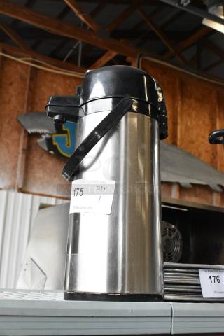 Stainless steel air pot with black plastic lid and handle, auction tag labeled 175. Good condition, ideal for hot beverages.