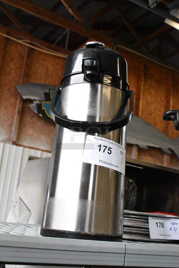 Stainless steel air pot with black lid and handle, in good condition. Auction tag marked "175" from PCIAuctions.com.