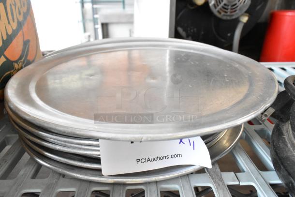 11 round metal baking pans, stacked. Slight surface wear. Tag shows "PCI Auctions" and "x11," indicating quantity.