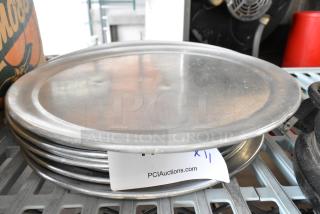 11 round metal baking pans, stacked. Slight surface wear. Tag shows "PCI Auctions" and "x11," indicating quantity.