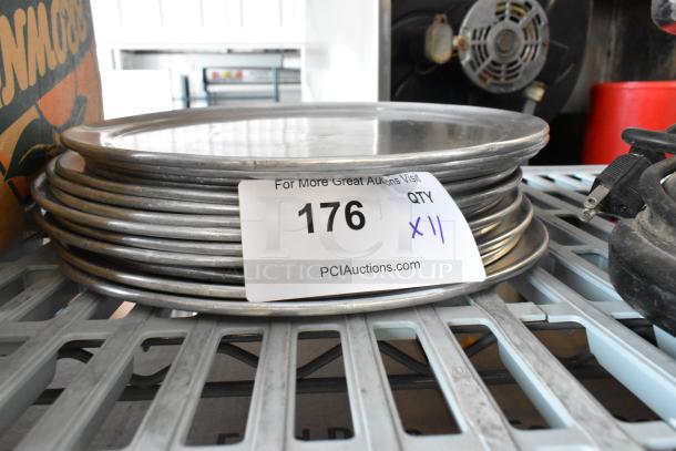 11 round metal baking pans stacked with lot tag 176, "11 Times Your Bid," indicating quantity, on a metal shelf.