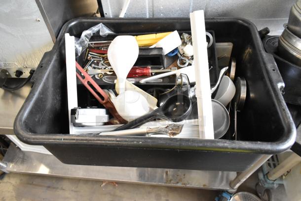 Lot of various items in black poly bus bin, includes utensils, kitchen tools, and assorted metal pieces. Used condition.