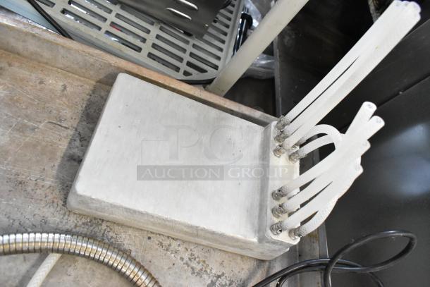 Lot including a metal cold plate with multiple attached flexible hoses, featuring a sturdy design; condition appears used.