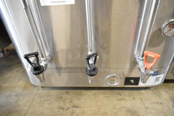 Curtis SCRU-300-12 stainless steel coffee urn with three spouts, tags visible, used condition, 208/220V, 1 phase.